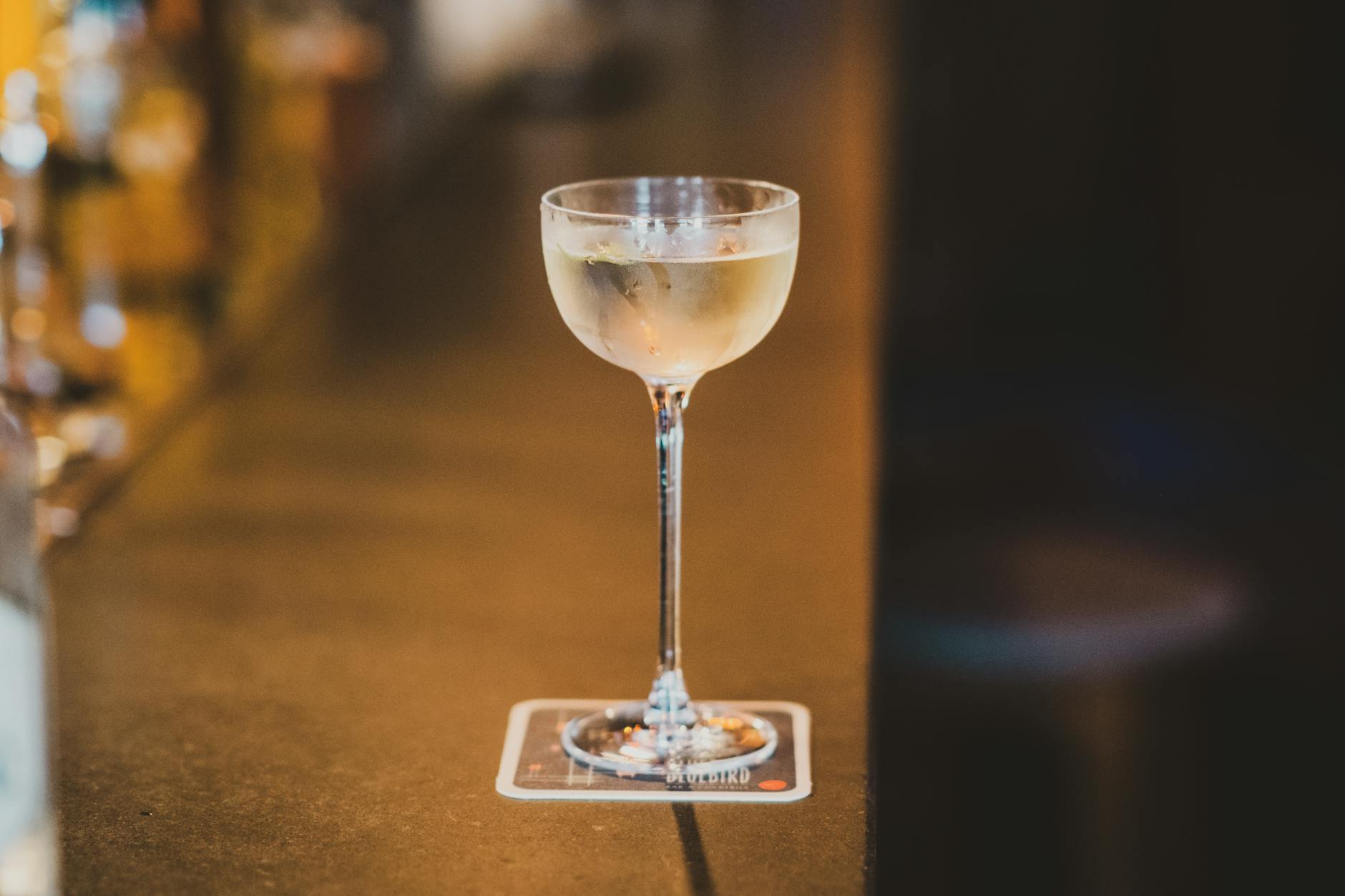 A glass of white wine on a bar counter