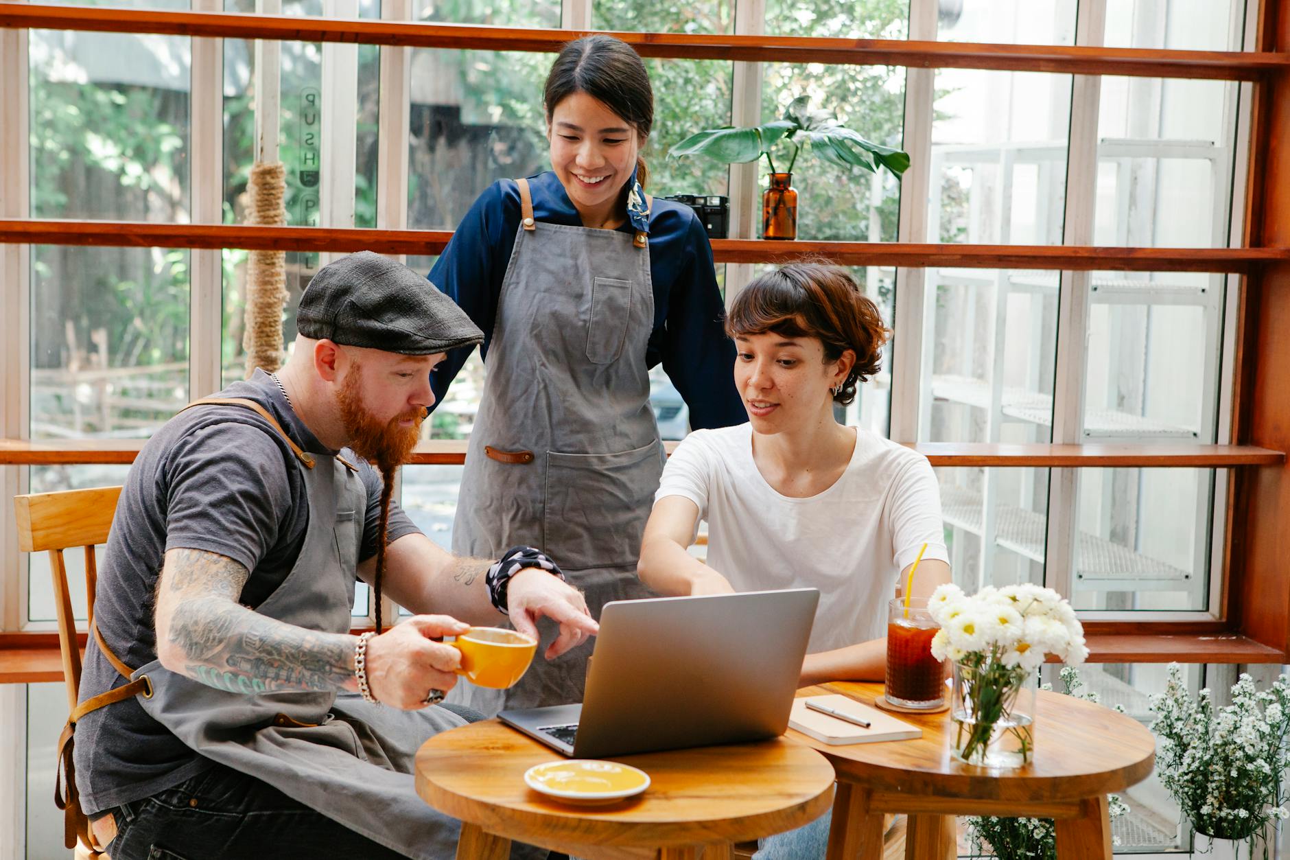 Interested multiethnic cafeteria staff sharing laptop at work