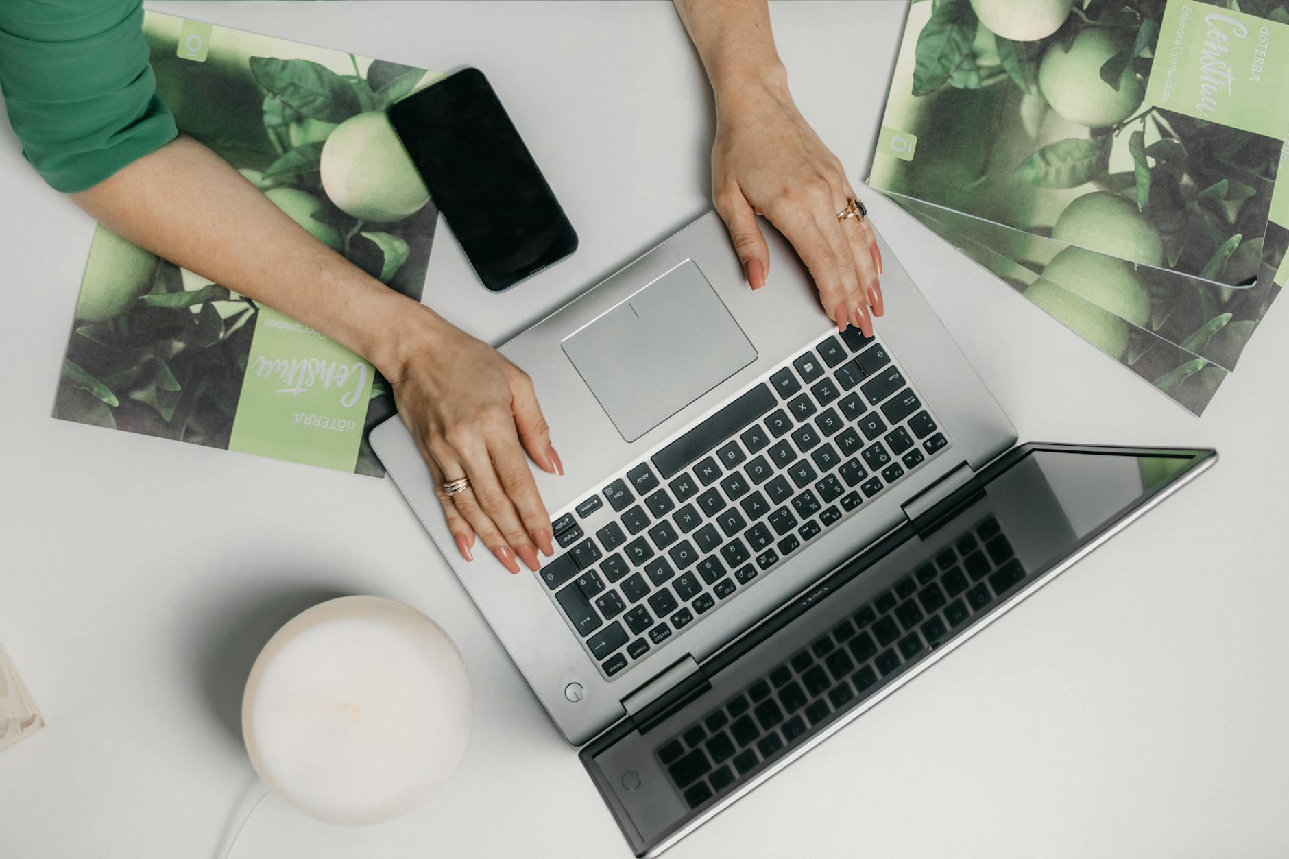 A woman's hands are on top of a laptop computer