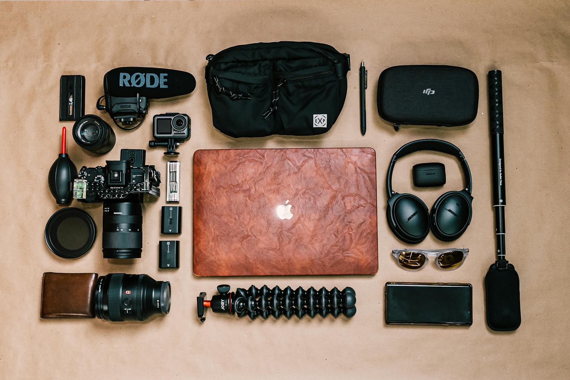 Overhead view of laptop and photo camera composed with headphones and other gadgets of professional photographer