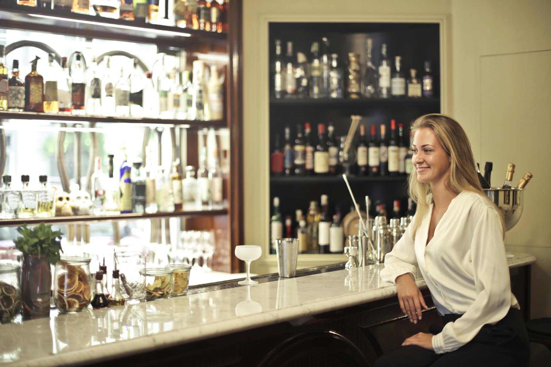 Woman in White Long Sleeve Leaning In Counter Table