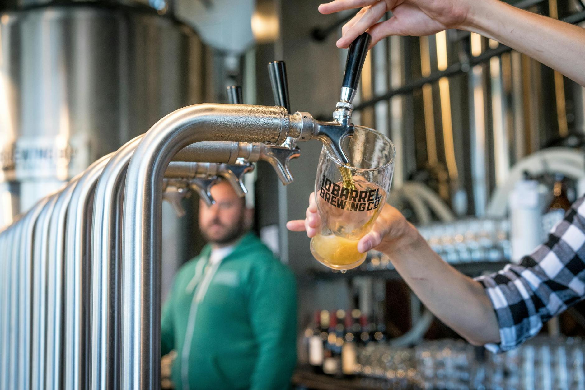 Person Filling Drinking Glass With Beer on Tap