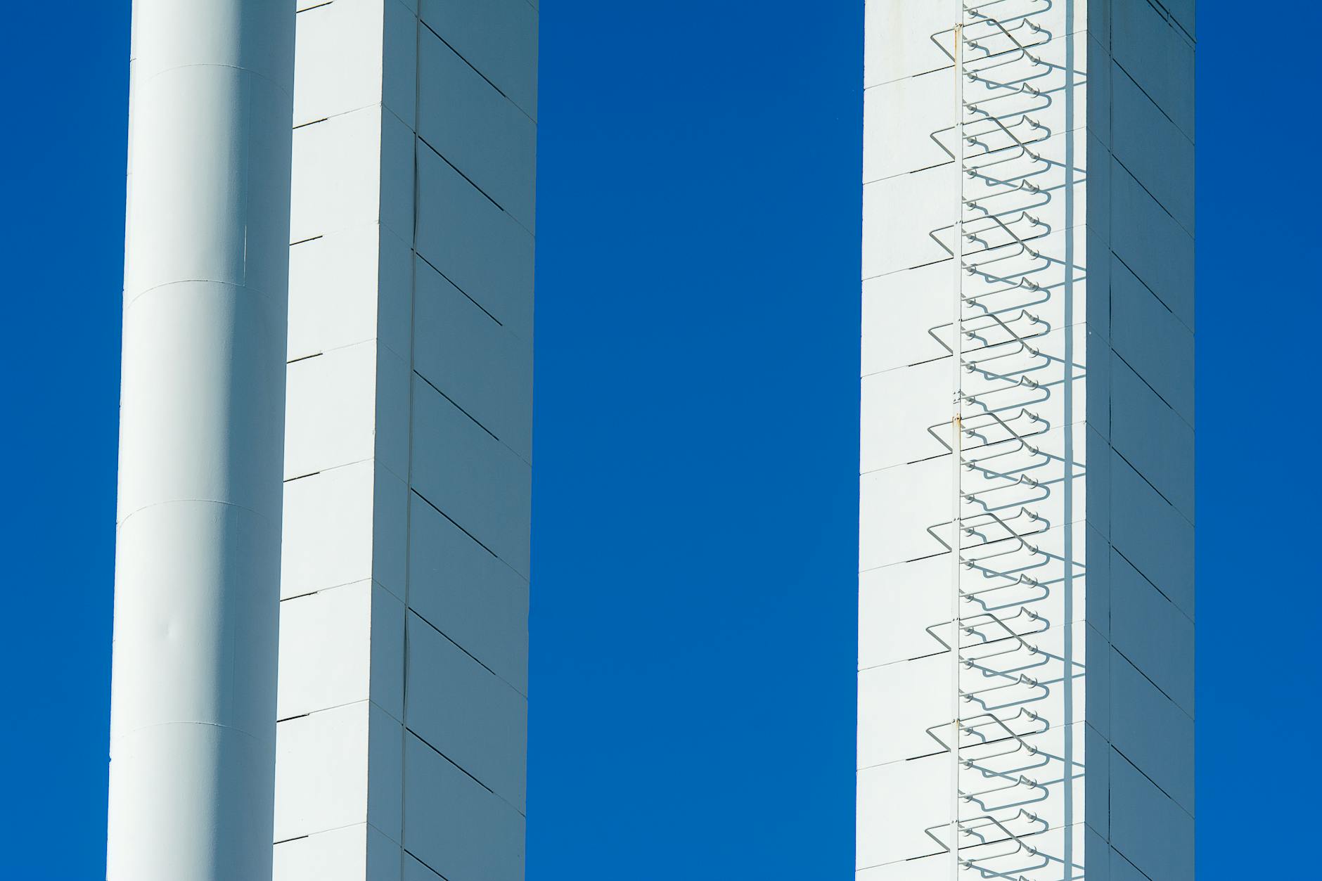 Two tall white columns with blue sky in the background