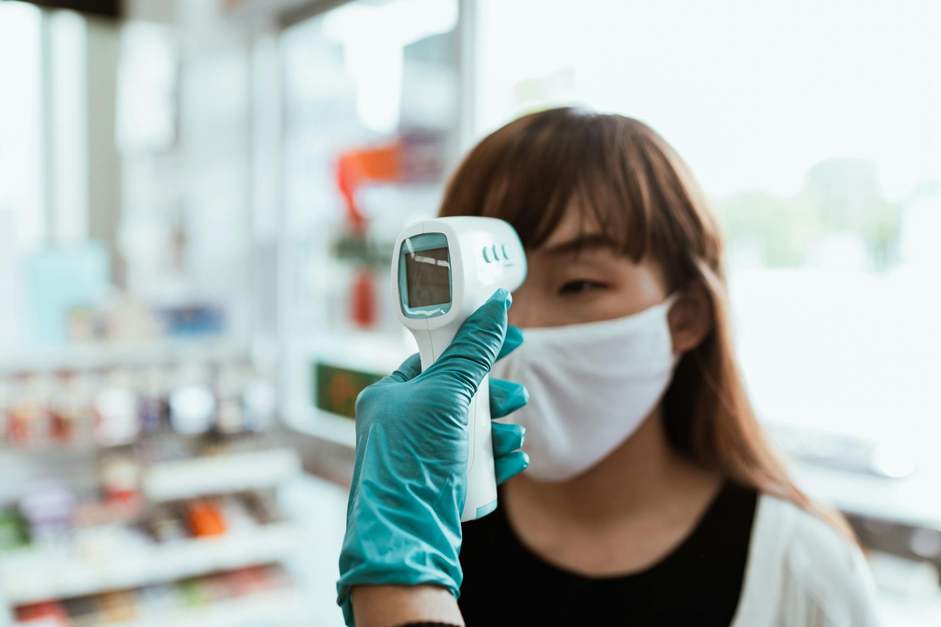 Woman Wearing a Face Mask Getting her Temperature Checked