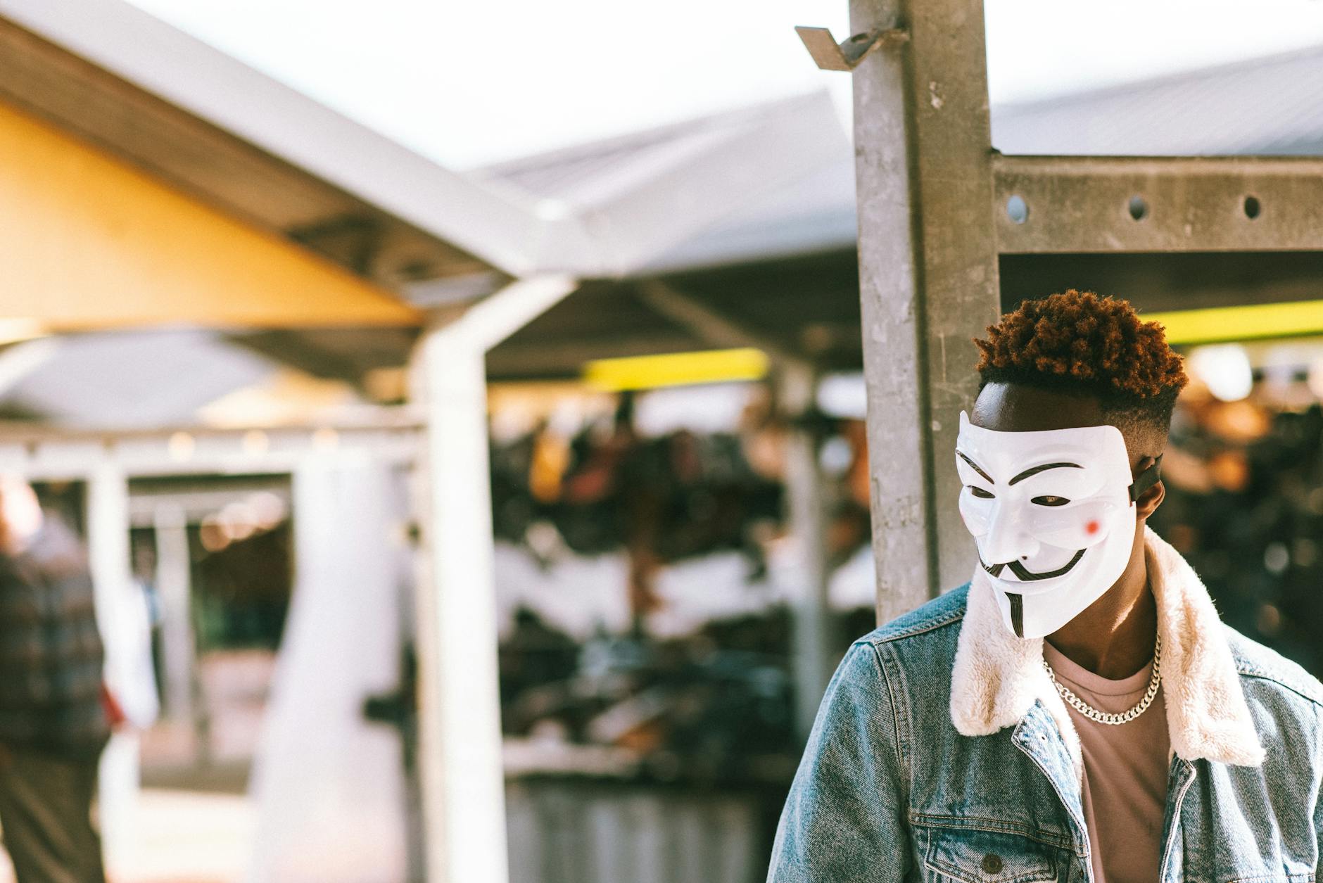 Ethnic protester in anonymous mask on city street