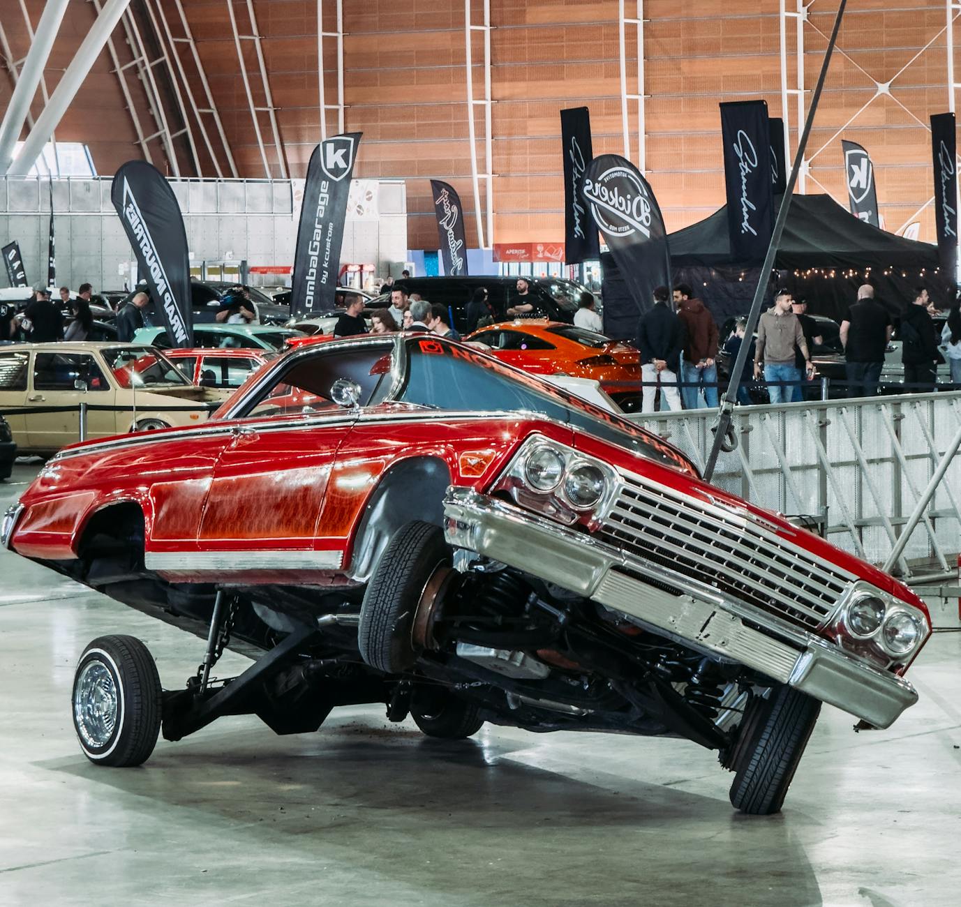 A red car is on its side in a showroom