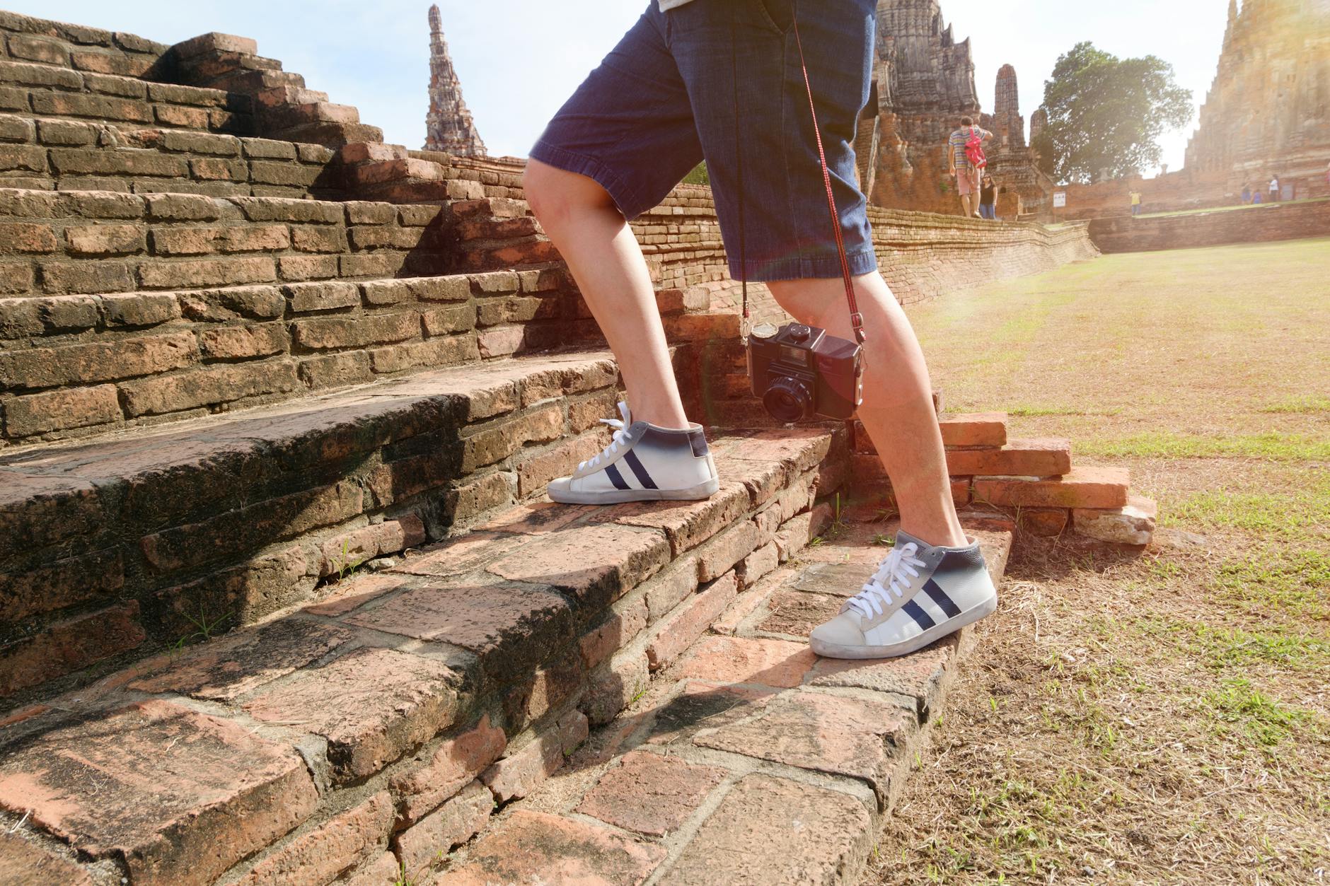 Person Wearing White-and-black Mid-rise Sneakers at Borobudur, Indonesia