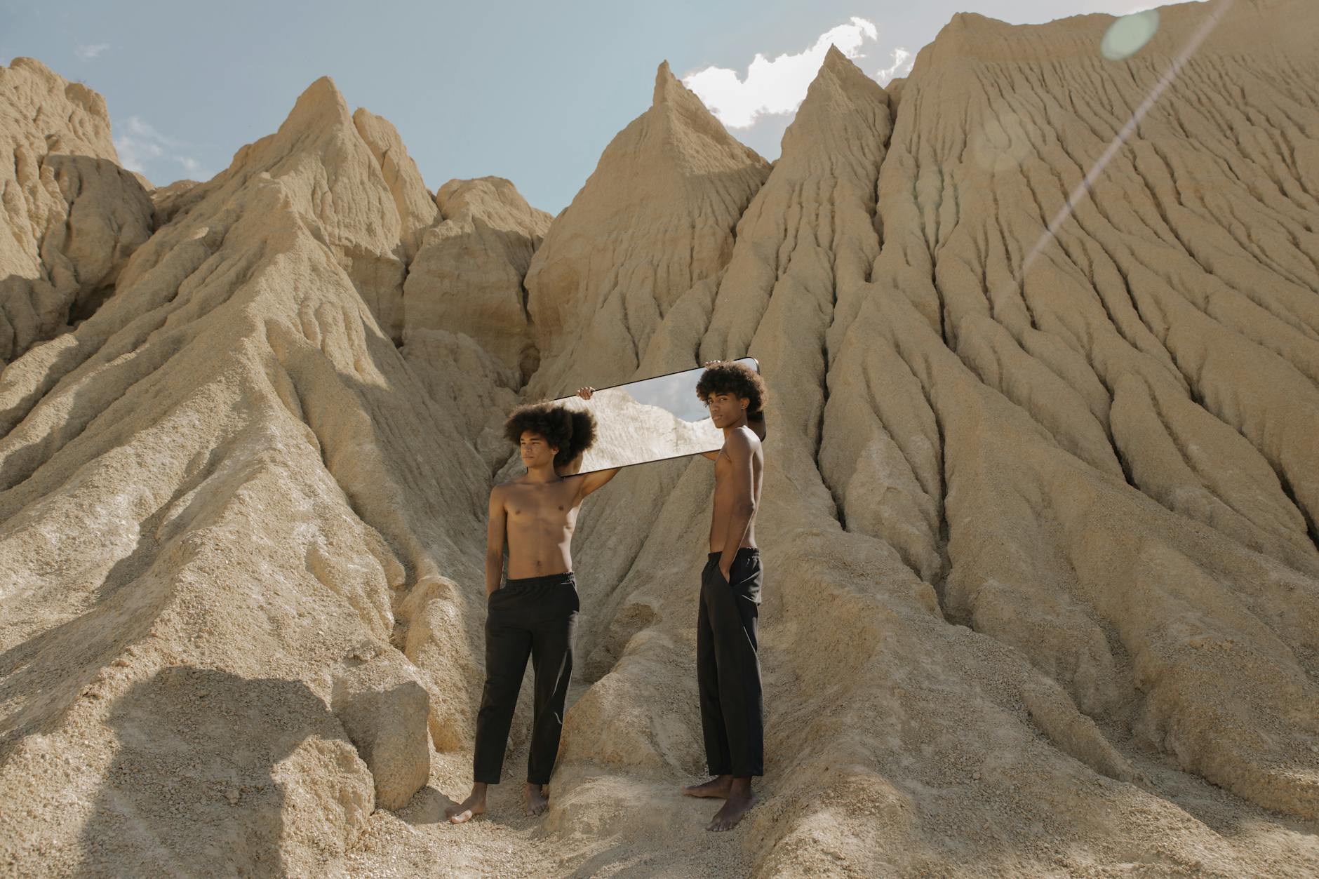 Two Men Holding a Mirror on Their Shoulders