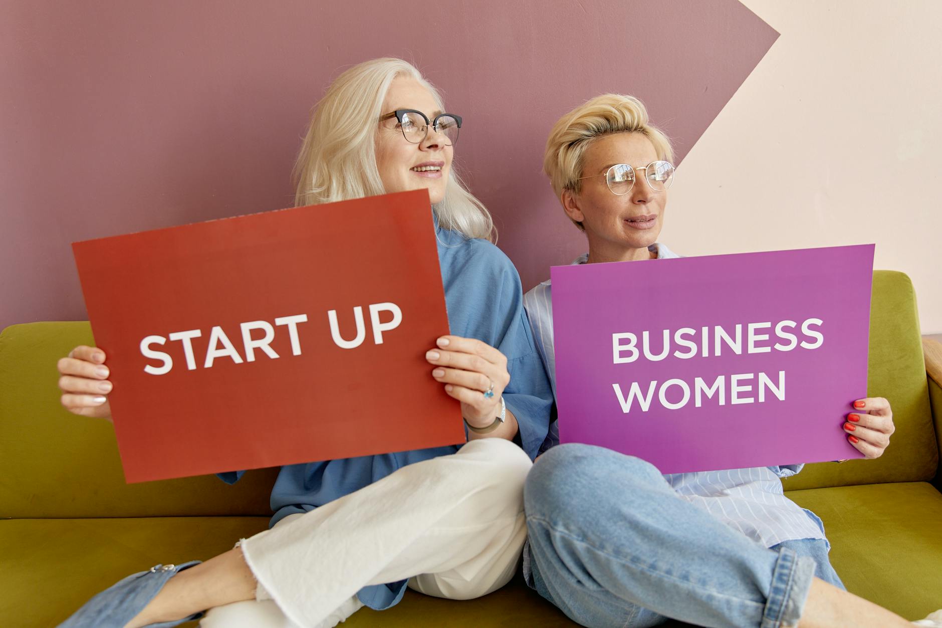 Elderly Women Wearing Eyeglasses Sitting on a Couch while Holding a Placard