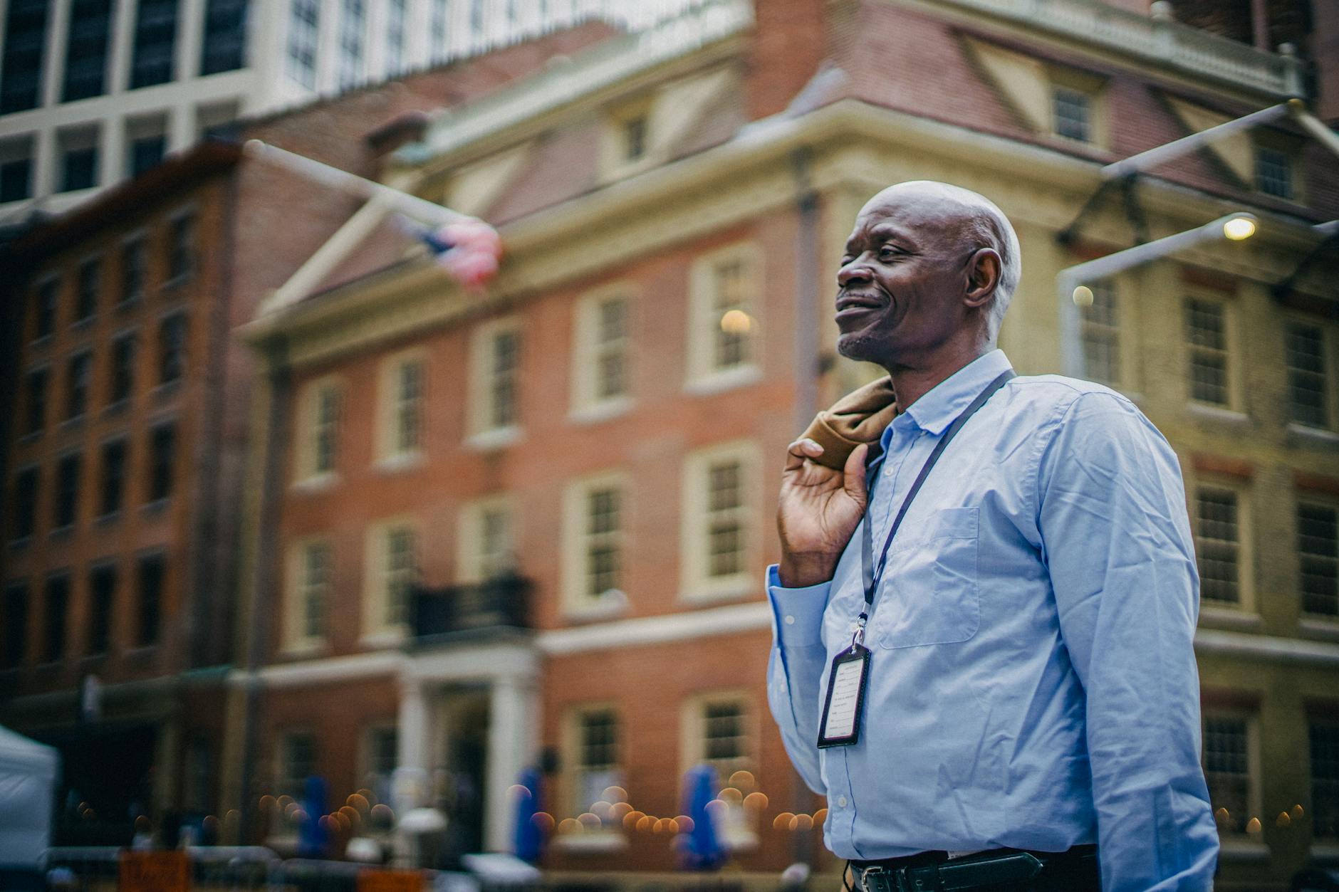 Positive black businessman standing on urban city street