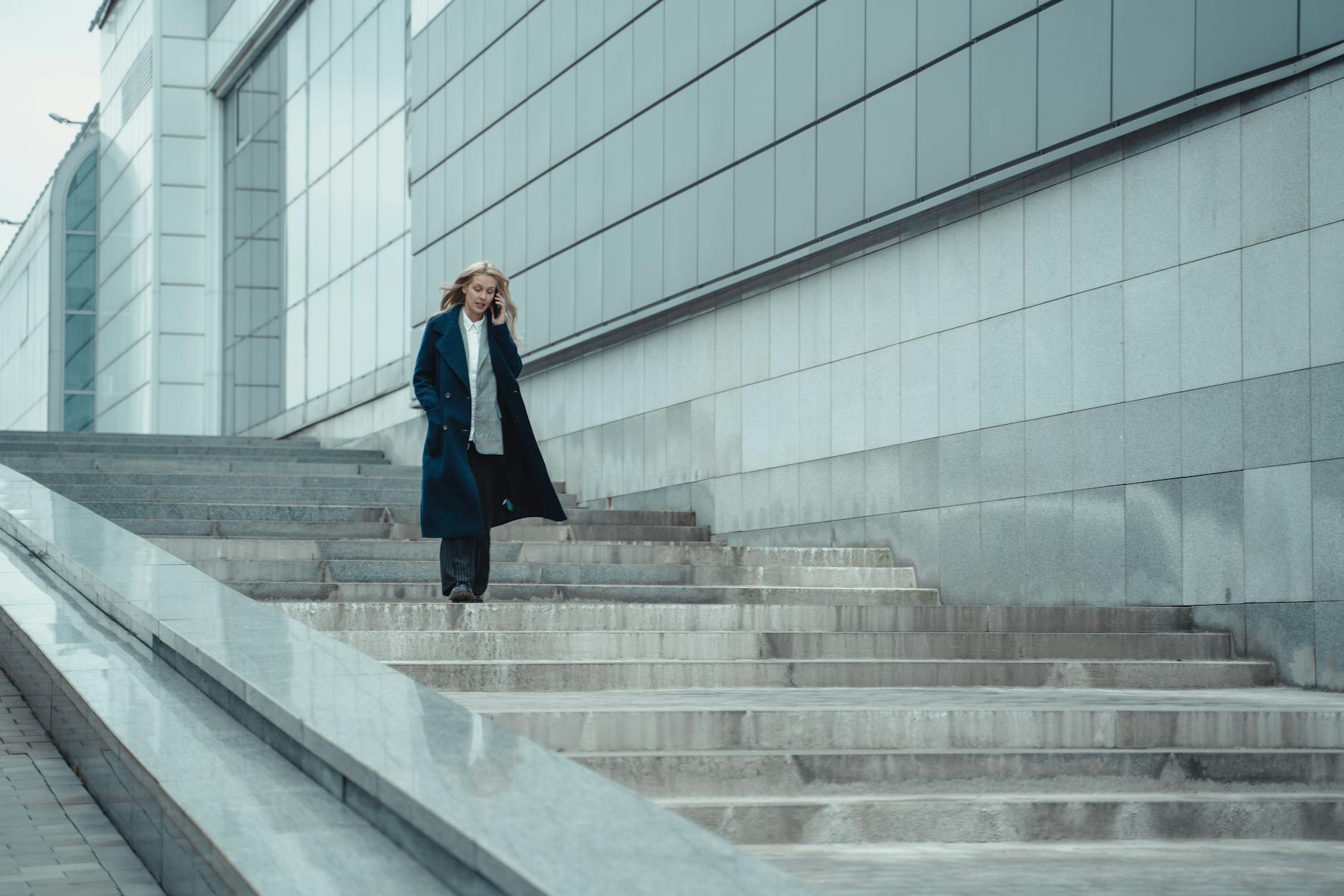 Blonde Woman Walking Downstairs While Holding Her Smartphone