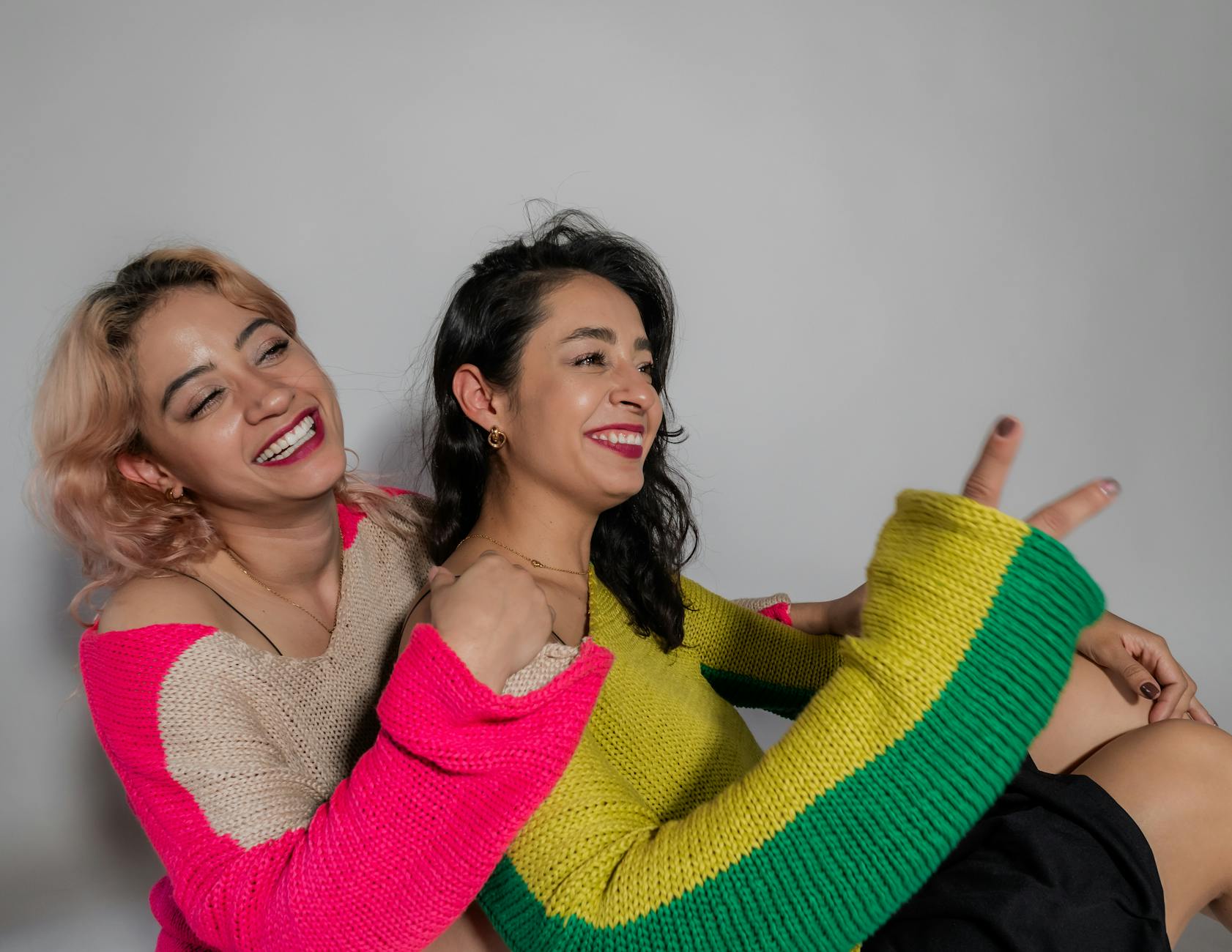 Joyful Women Embracing Friendship in Colorful Sweaters