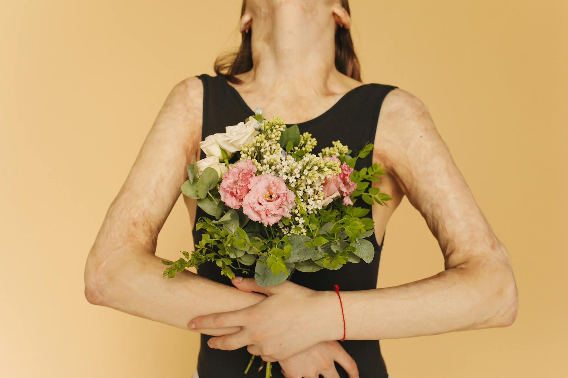 A Woman in Black Tank Top Holding a Bouquet of Flowers