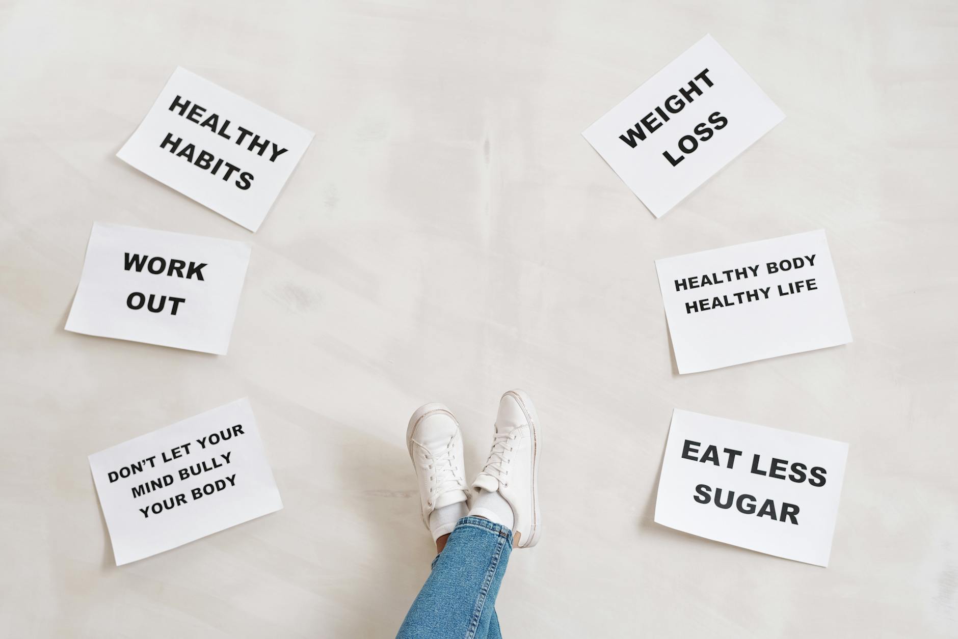 Person Legs with Motivational Words on Papers on White Background