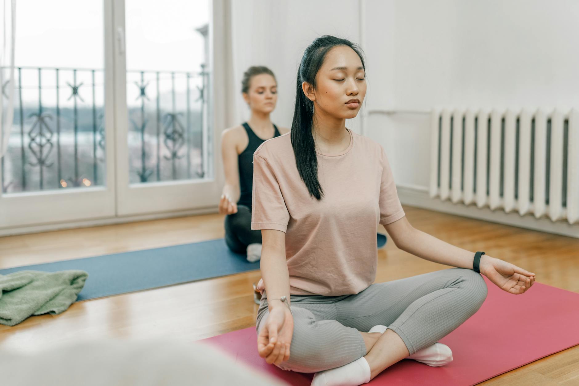 A Woman in Beige Crew Neck T-shirt and Gray Leggings Meditating