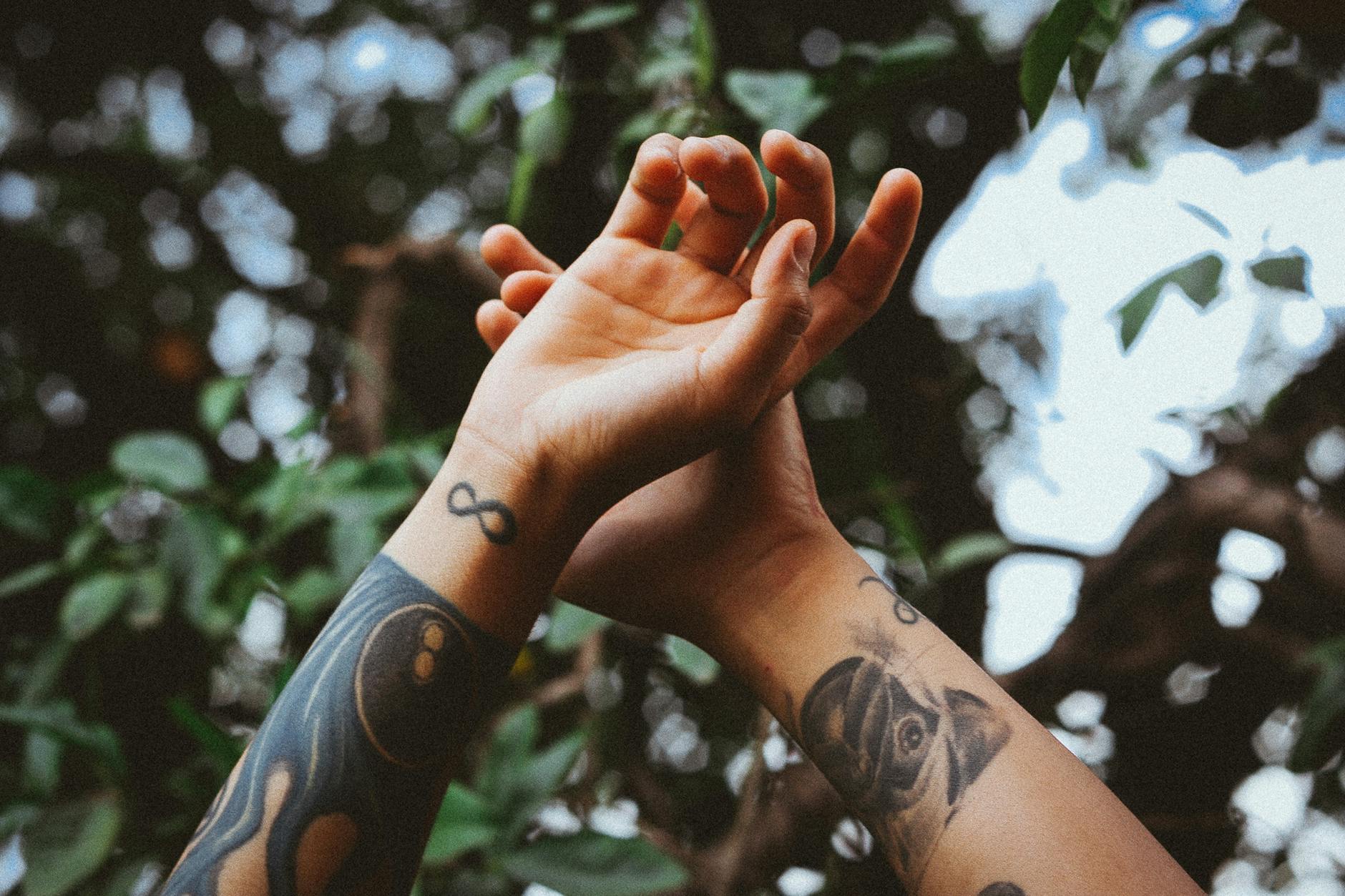 Close-Up Photo of Arms With Tattoos