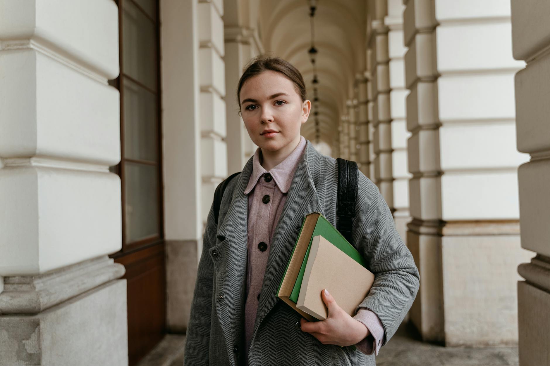 A Woman Wearing Black Backpack Carrying Books