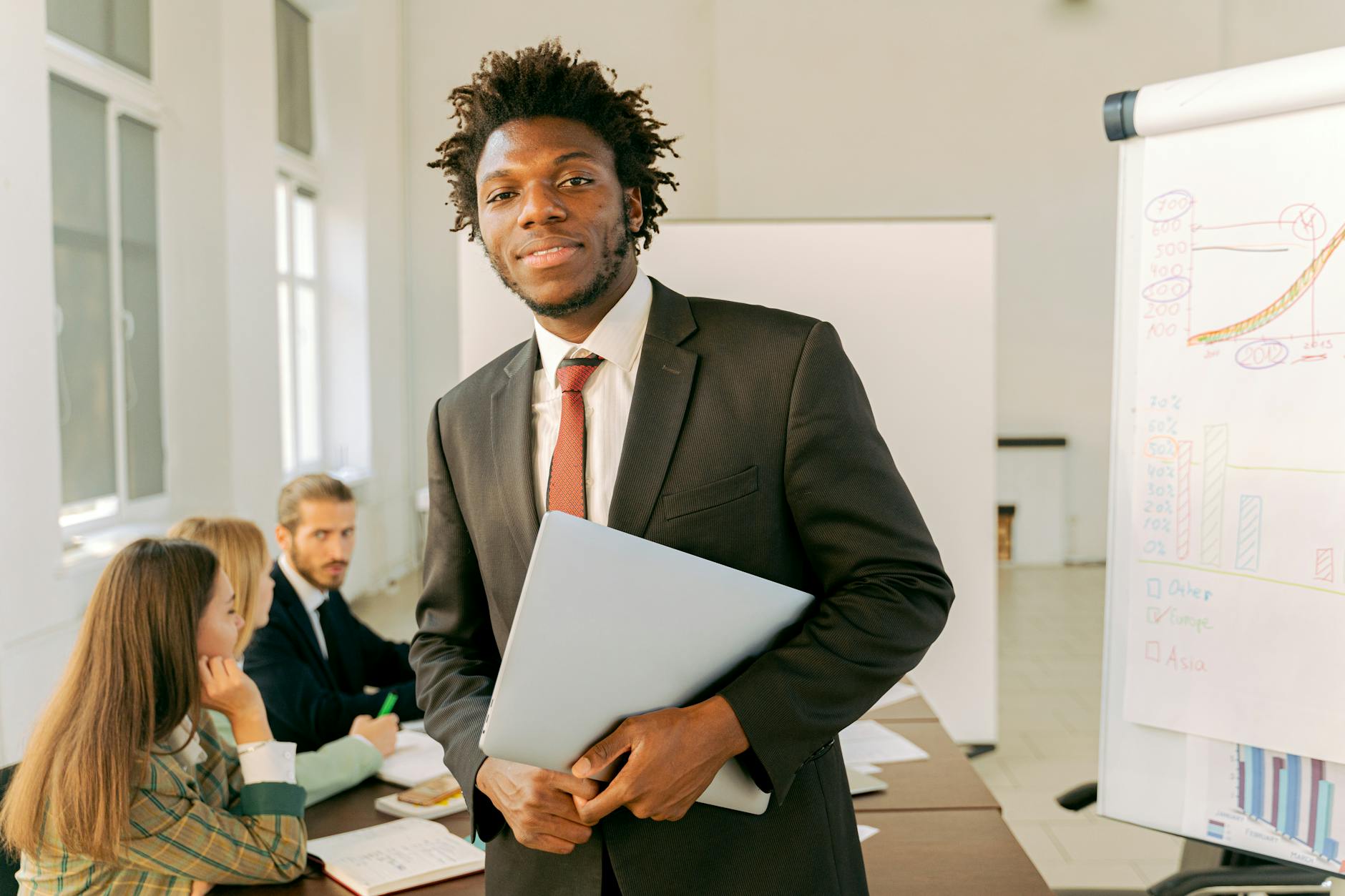 A Man in Black Suit Holding a Laptop